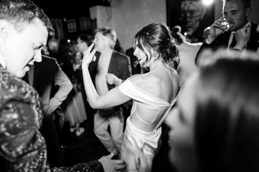 Bride dancing joyfully at Voewood wedding reception in black and white.