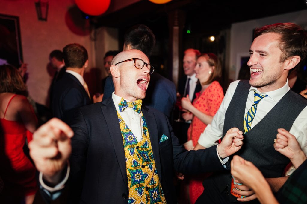 Men dancing and laughing at a party.