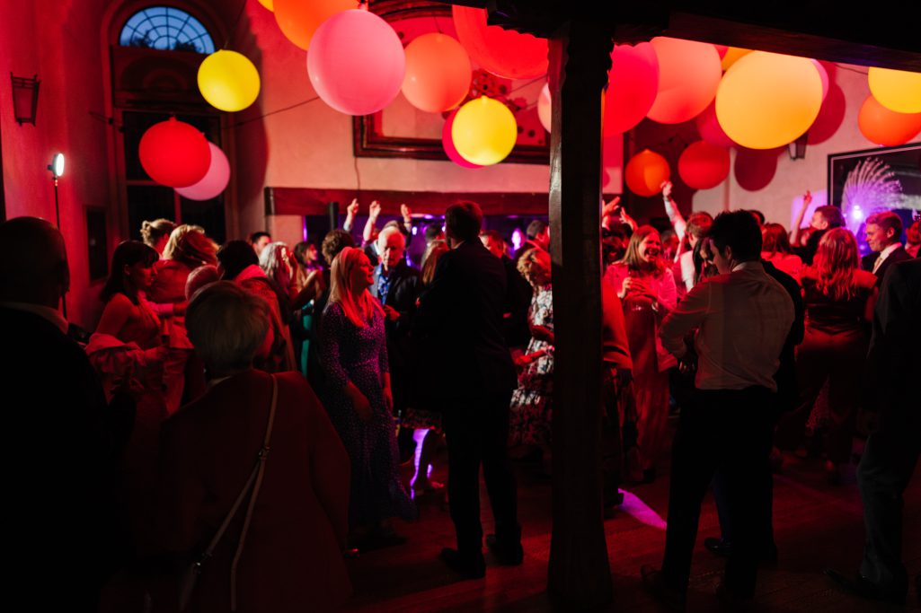 Lively evening party with colorful balloons and dancing guests.