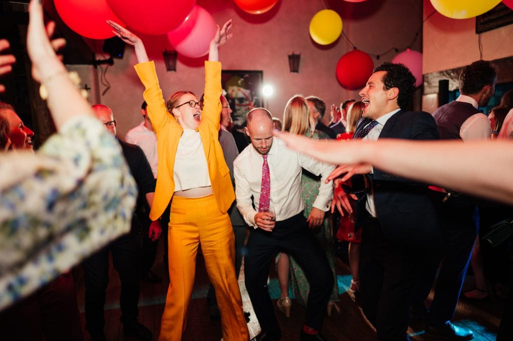 People celebrating at a lively Voewood Wedding party with balloons.