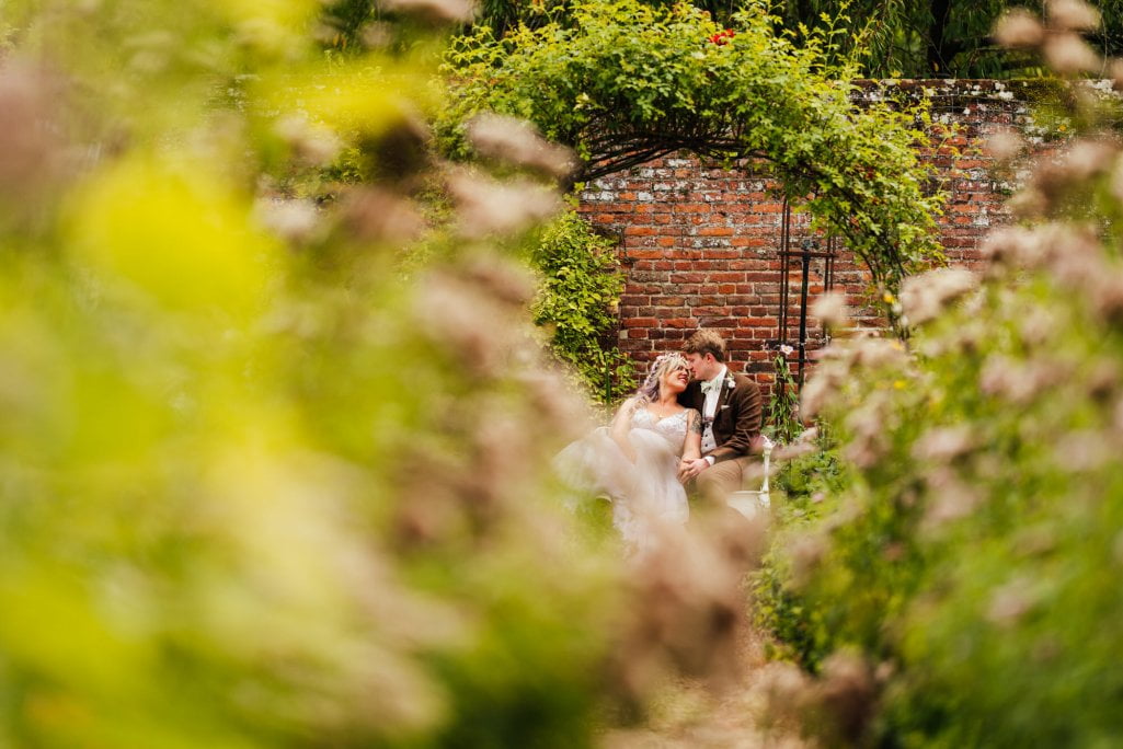 Couple embracing in garden, romantic wedding scene.