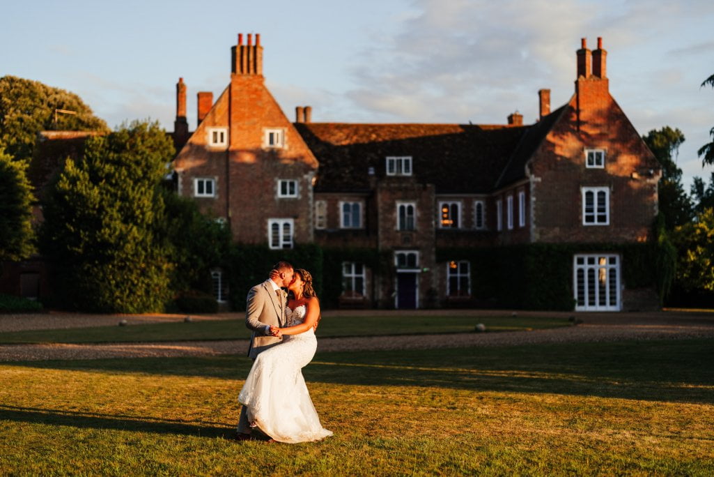 Couple kissing at sunset, English country house wedding.