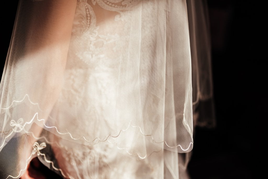 Delicate bridal veil and lace dress detail.