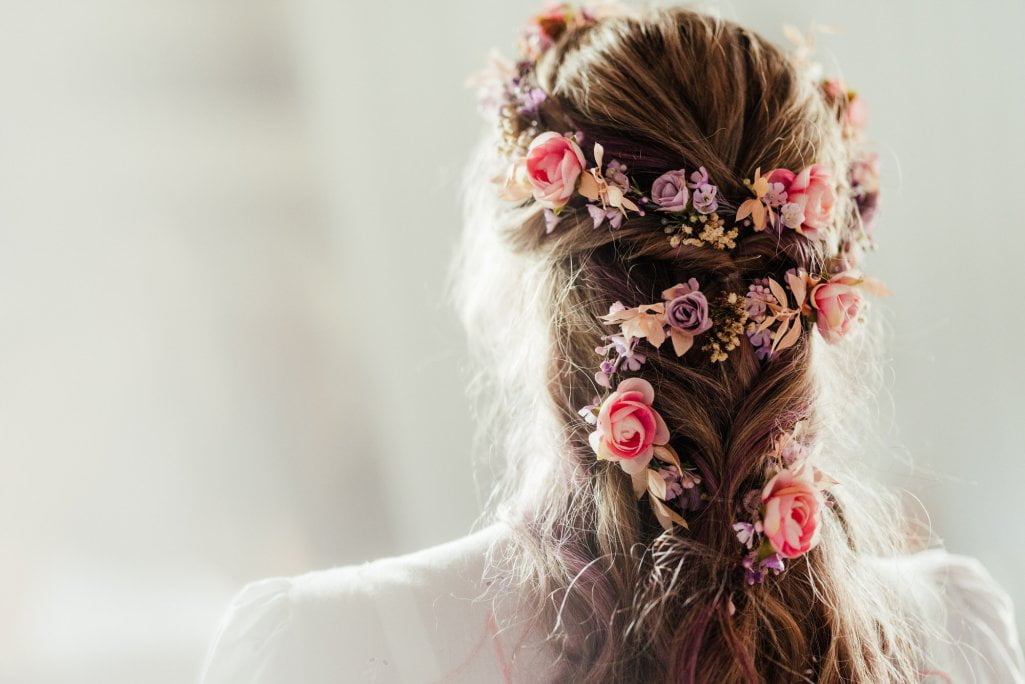 Bride with floral hairpiece from behind.