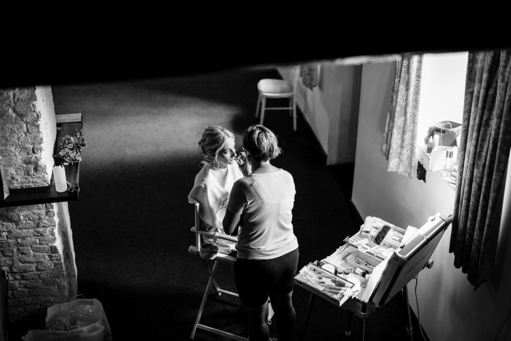 Makeup artist working with client in monochrome setup.